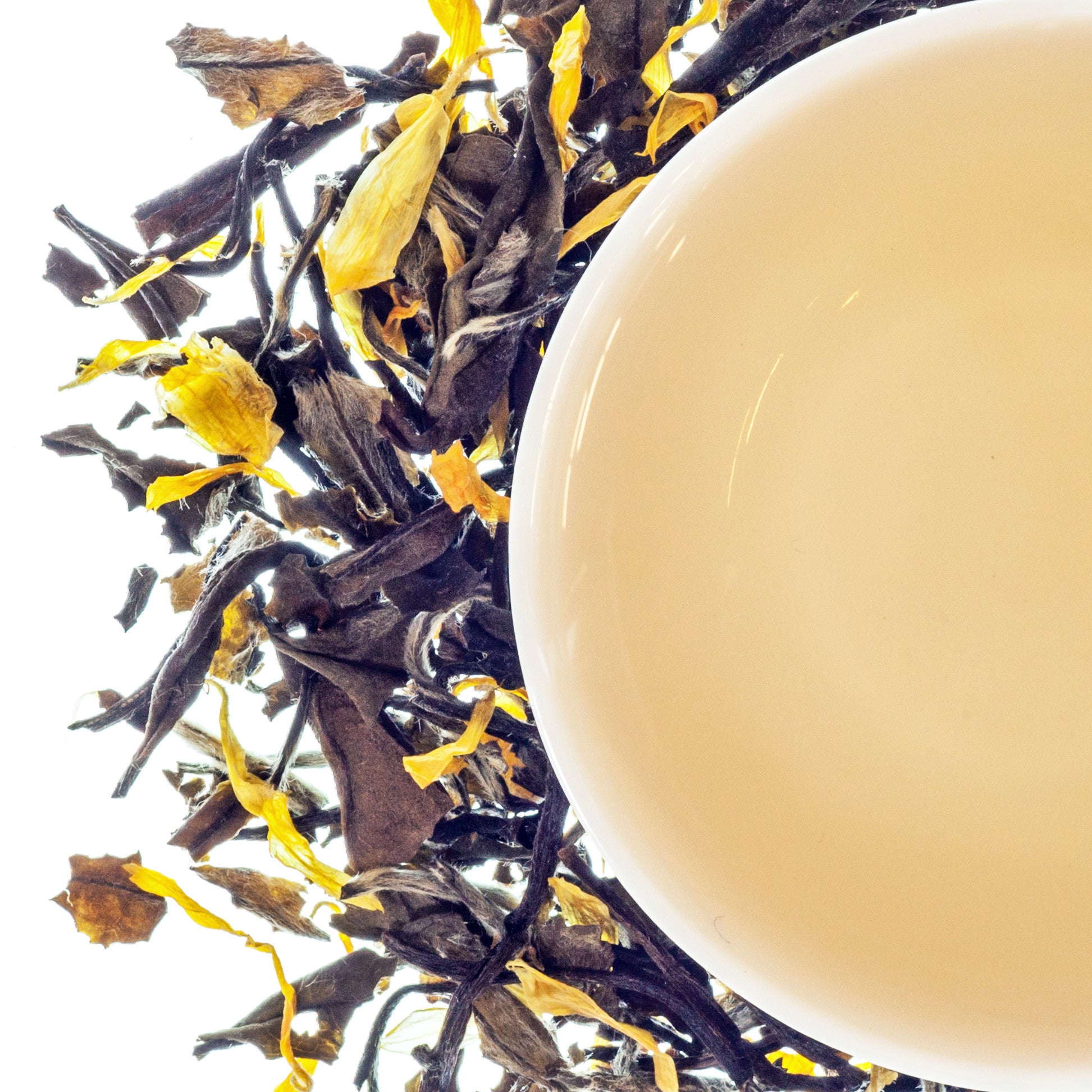 A top-down image of a white tea bag with loose tea leaves scattered around, presenting a peach-like aroma.