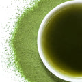 A bowl of matcha with matcha powder around it on a white background
